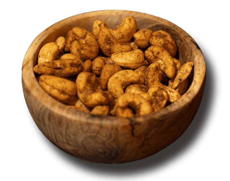 Roasted cashews covered in Indian spices in a wooden bowl